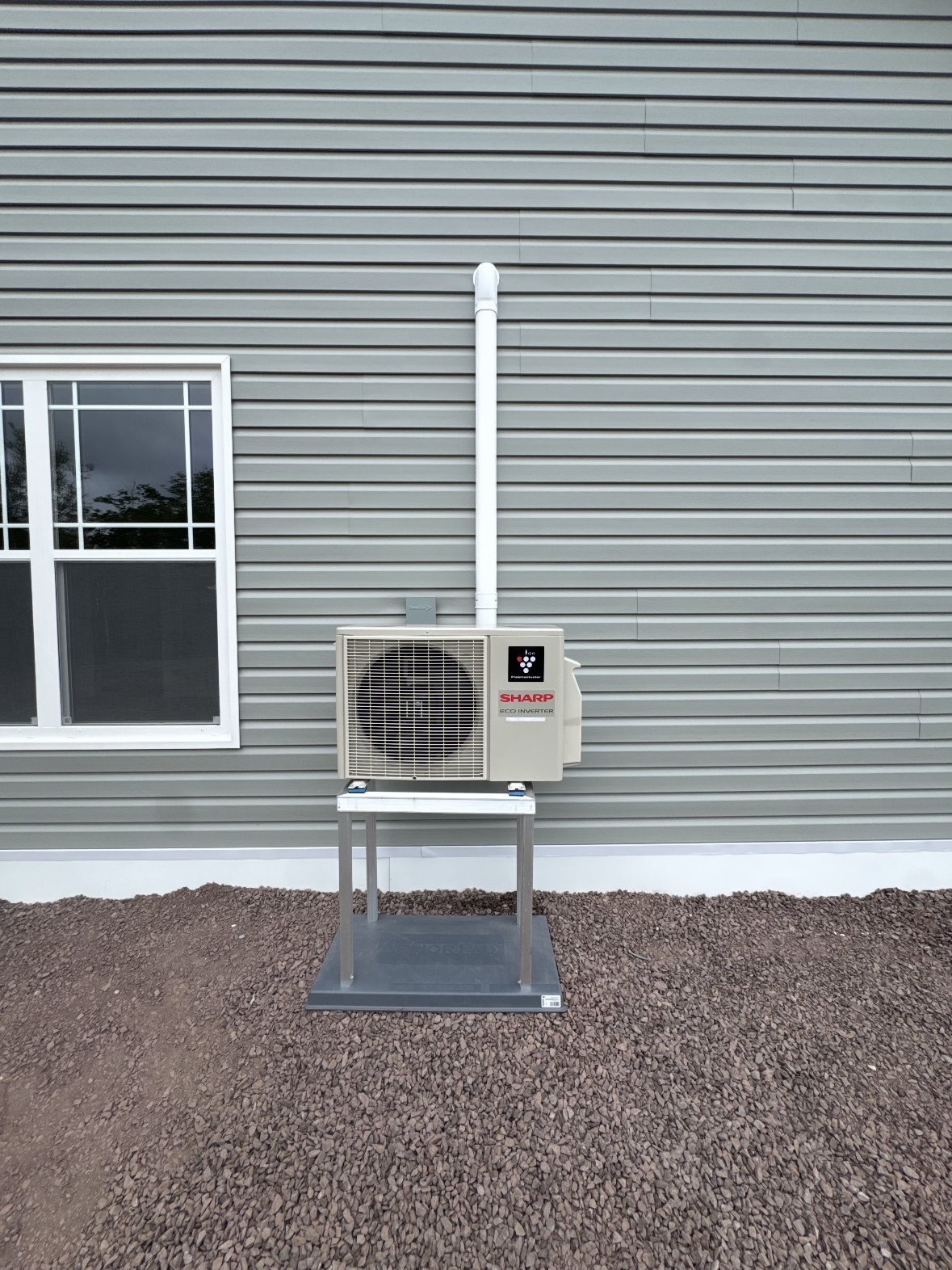 Sharp eco inverter heat pump condenser installed on exterior wall